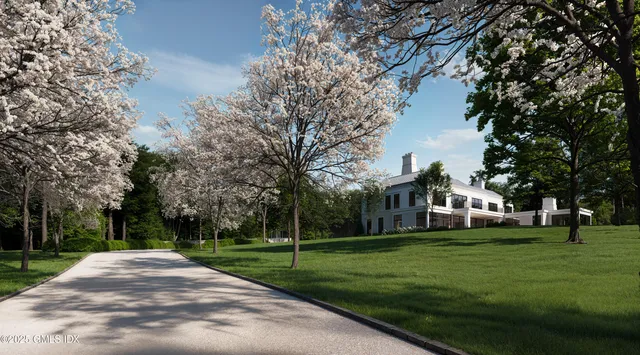 a view of a white house with a big yard and potted plants and large trees