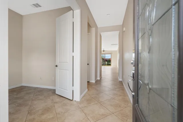 a view of an empty room with a chandelier fan