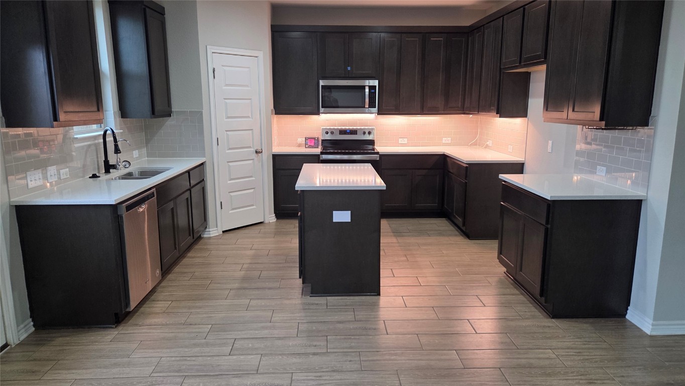 a kitchen with a sink stove and cabinets