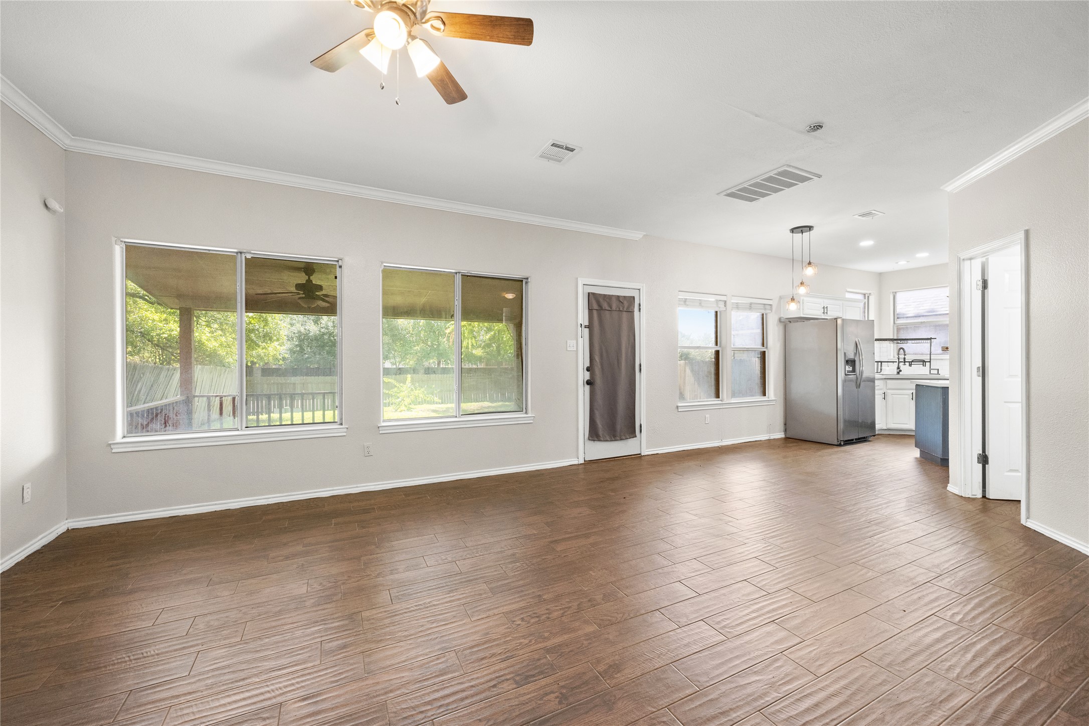 13217 Rochester Lane Austin, TX 78753 - Photo 3 of 30 Rich wood-look flooring and crown molding define this open main living space.