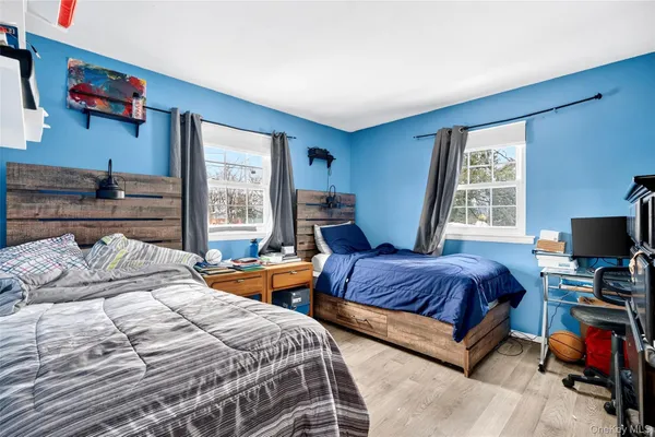 a bedroom with beds and a large window