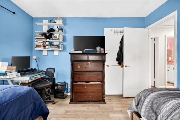 a bedroom with a bed and a computer on a desk