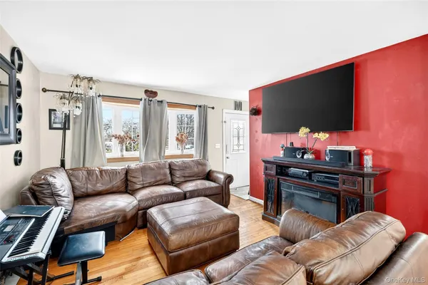a living room with furniture a flat screen tv and a window