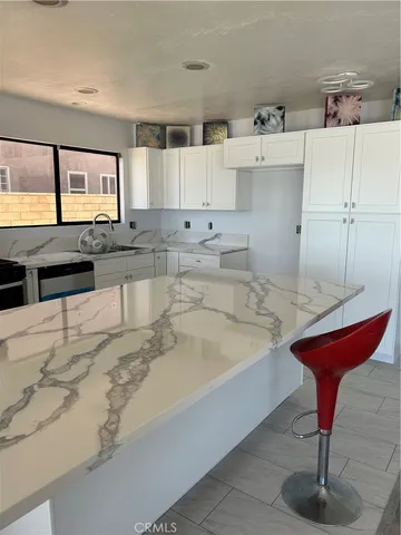 a large kitchen with kitchen island stainless steel appliances a sink and cabinets