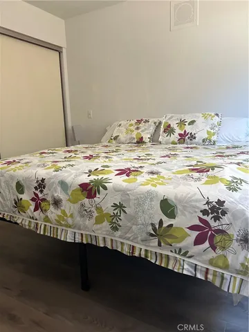 a view of a bedroom with bed and wooden floor