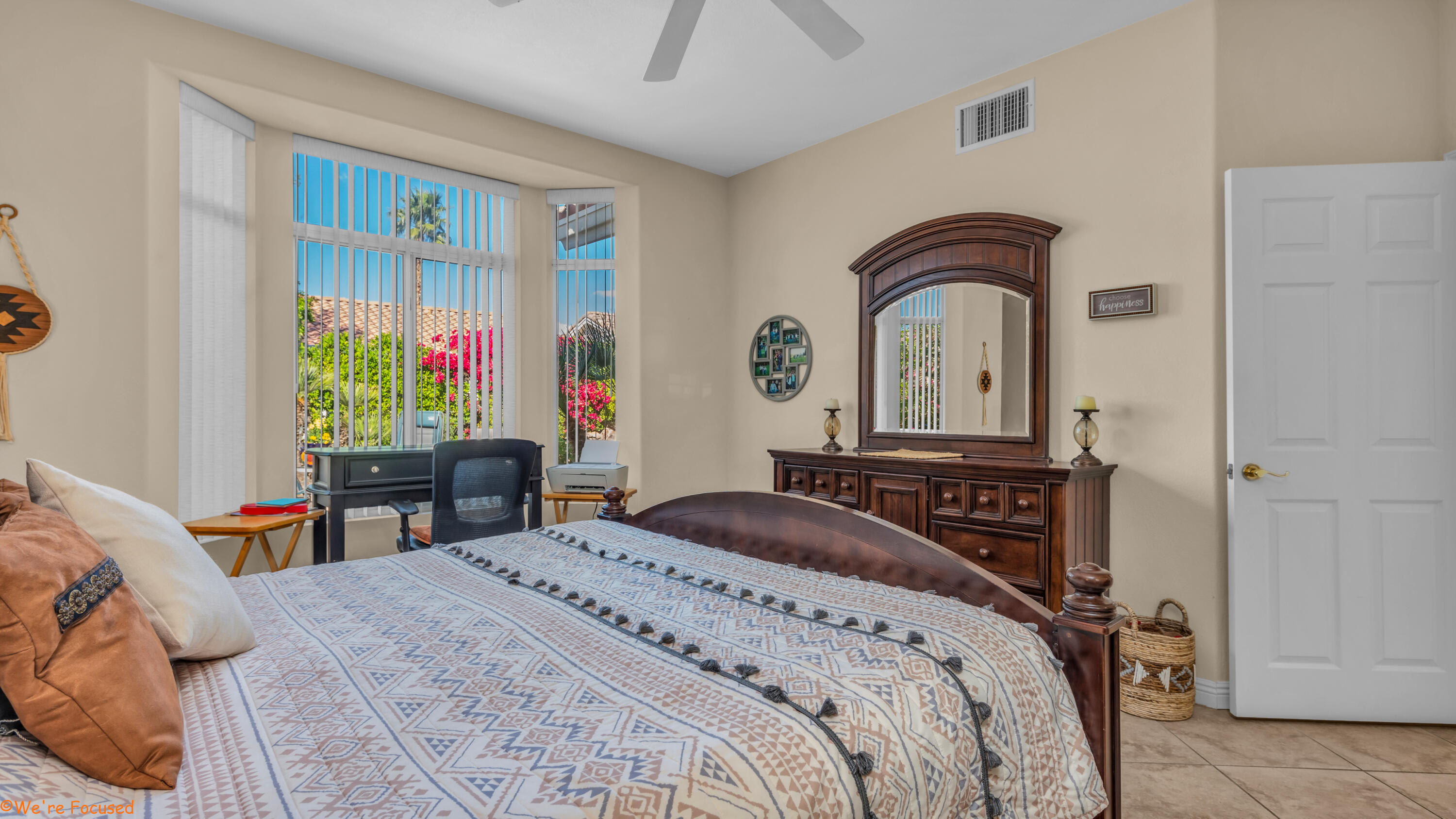 78326 Moongold Road Palm Desert, CA 92211 - Photo 17 of 33 a bedroom with a bed a dresser and a chandelier