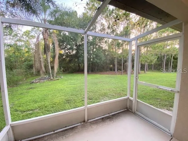 a view of outdoor space with a window and tall trees