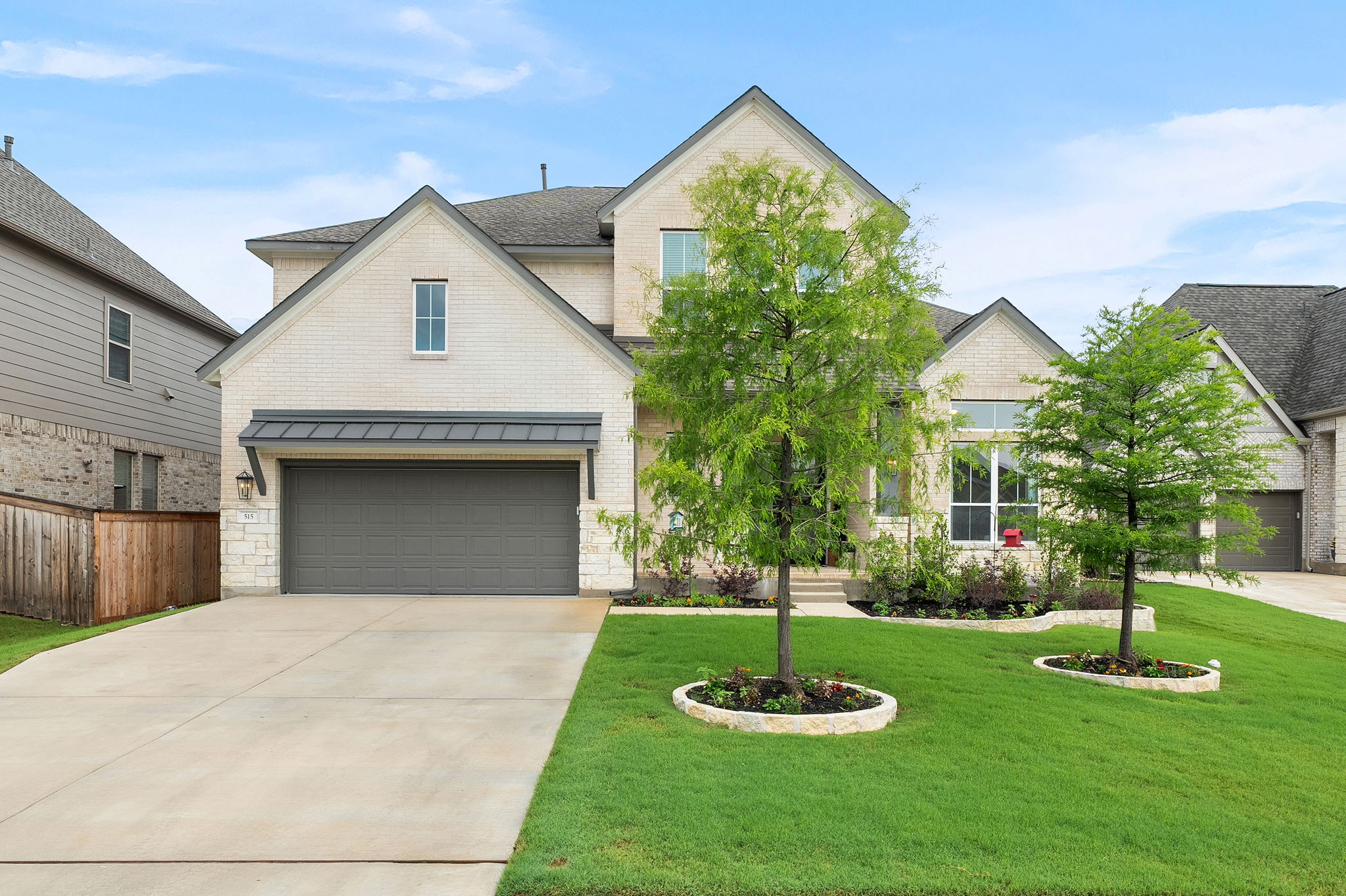 515 Watershield Cove Georgetown, TX 78633 - Photo 1 of 40 A well-kept front yard and a concrete driveway lead to a stylish brick home with a two-car garage.