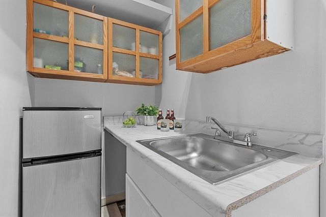 a kitchen with stainless steel appliances granite countertop a sink and a refrigerator