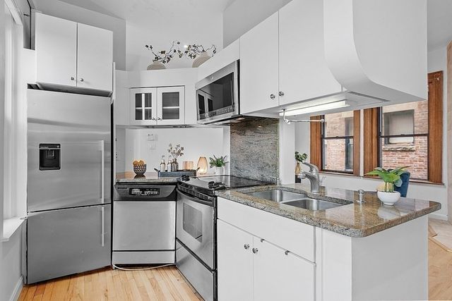 a kitchen with stainless steel appliances granite countertop a sink and a refrigerator