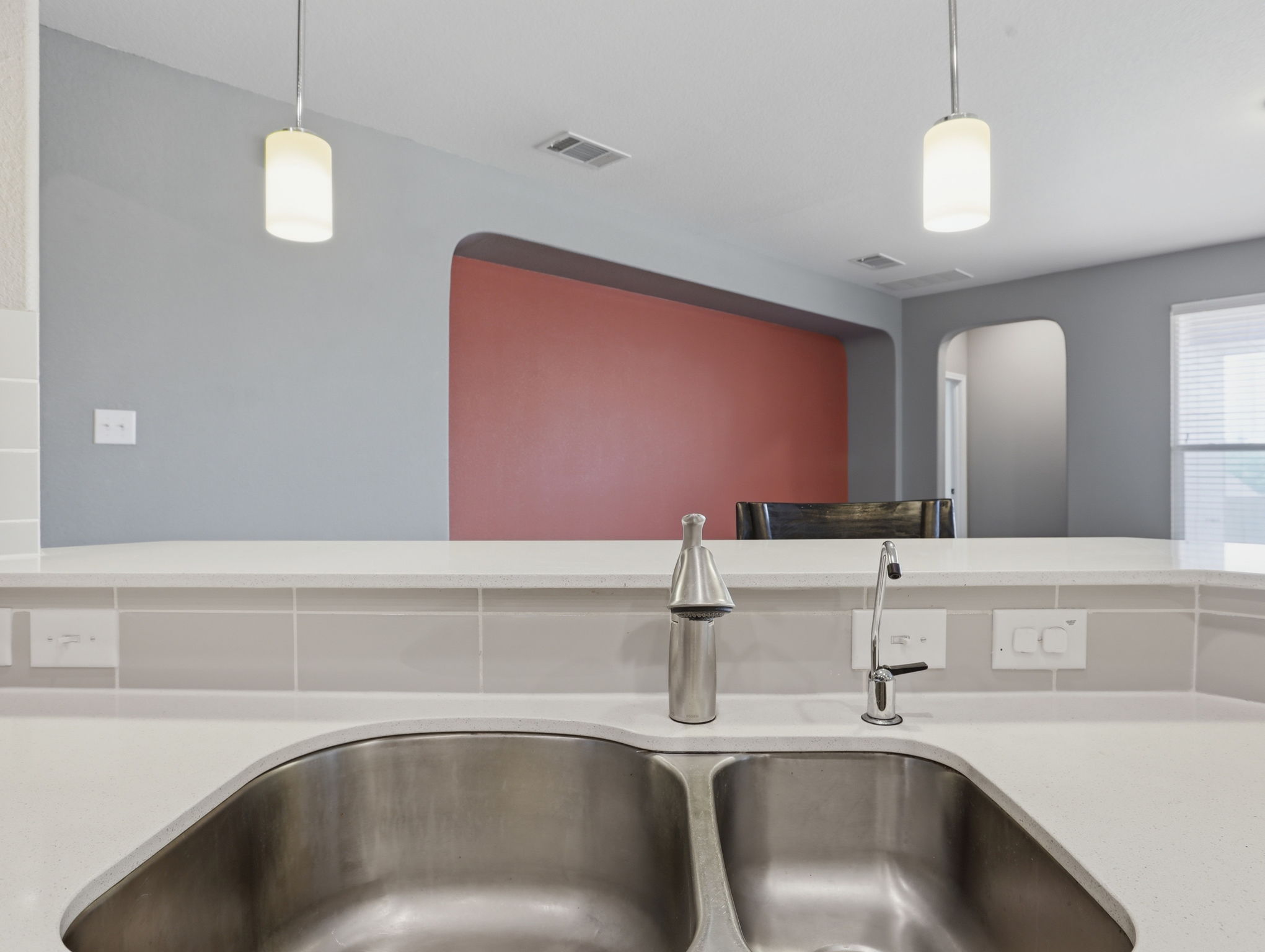 640 Landon Samuel Loop Pflugerville, TX 78660 - Photo 13 of 33 Kitchen sink area featuring a dual-basin stainless steel sink, a brushed nickel faucet, and a separate water filtration faucet