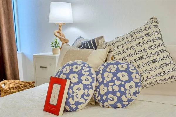 a bedroom with a bed and a lamp on dresser