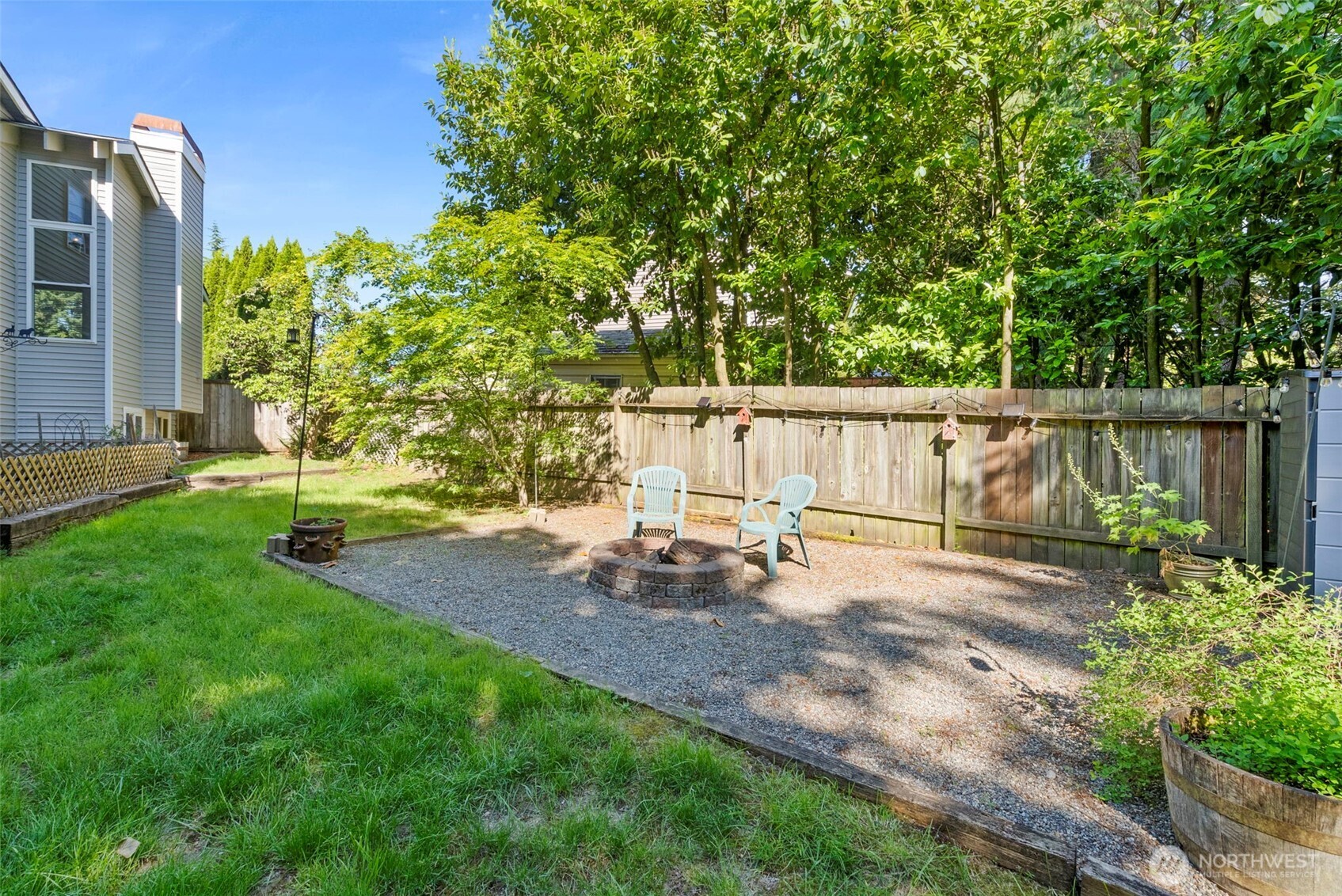 13603 Southeast 239th Street Kent, WA 98042 - Photo 22 of 23 a backyard of a house with table and chairs a barbeque with potted plants and large trees