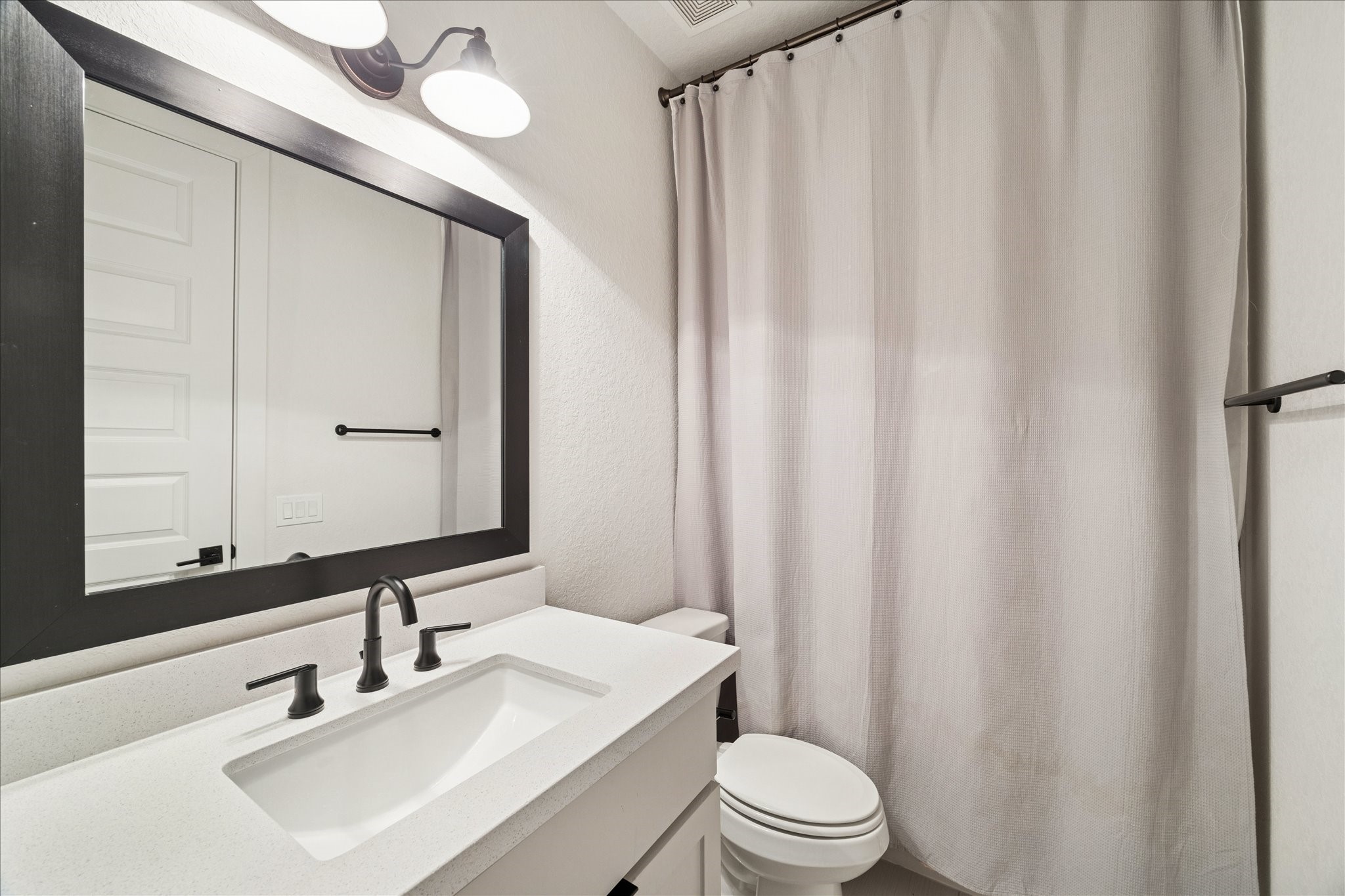 1122 Thompson Street Houston, TX 77007 - Photo 24 of 25 a bathroom with a sink a toilet a mirror and shower curtain