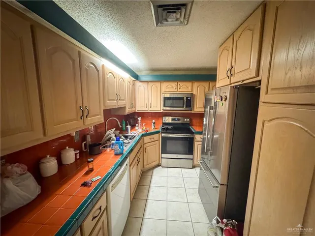a kitchen with stainless steel appliances a refrigerator sink and stove