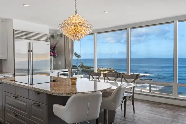 a very nice looking dining room with a large window and kitchen view