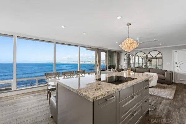 a kitchen with a stove and a view of living room