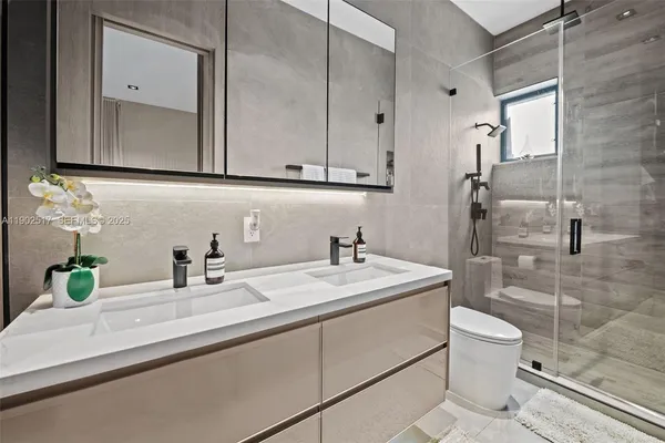 a bathroom with a sink a toilet and shower