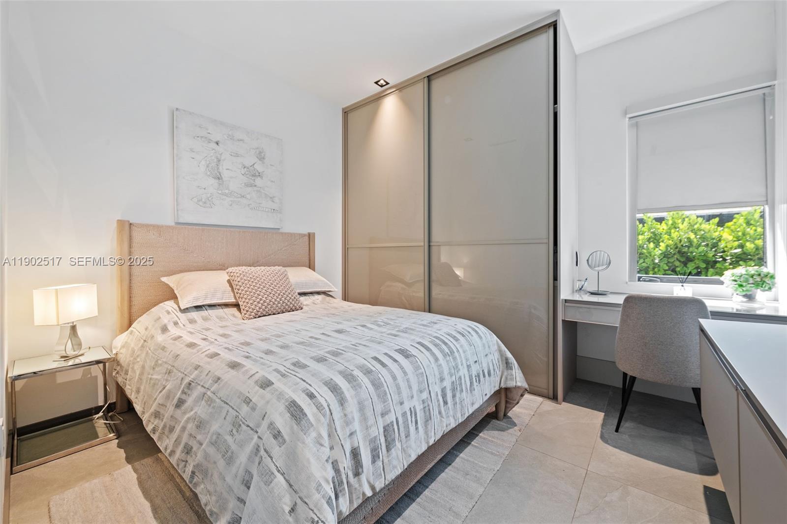 655 Layne Boulevard Hallandale Beach, FL 33009 - Photo 20 of 46 a bedroom with a bed table chair and a window