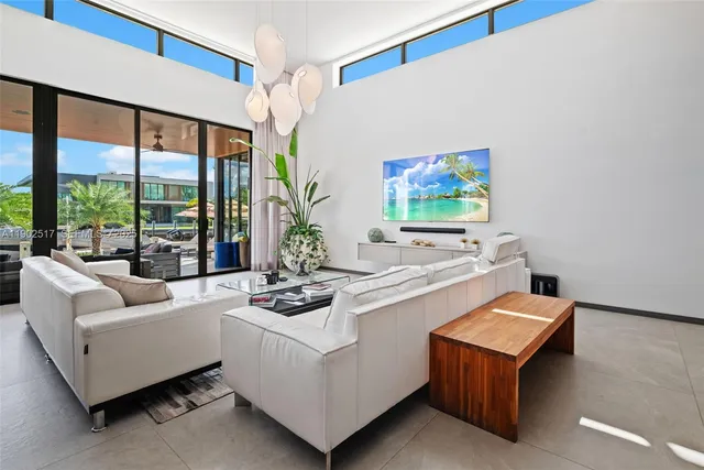 a living room with furniture a floor to ceiling window and a flat screen tv