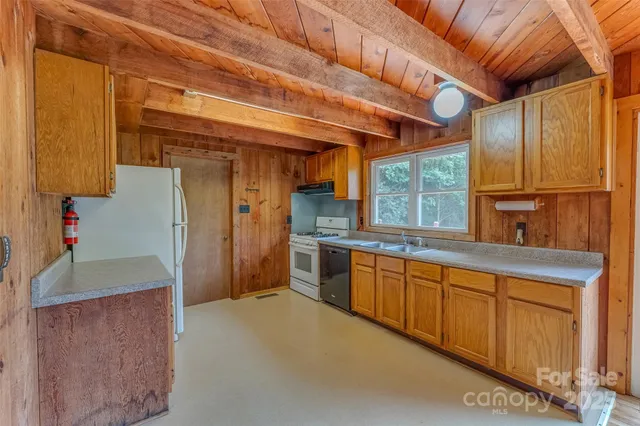 a open kitchen with granite countertop a sink window and refrigerator