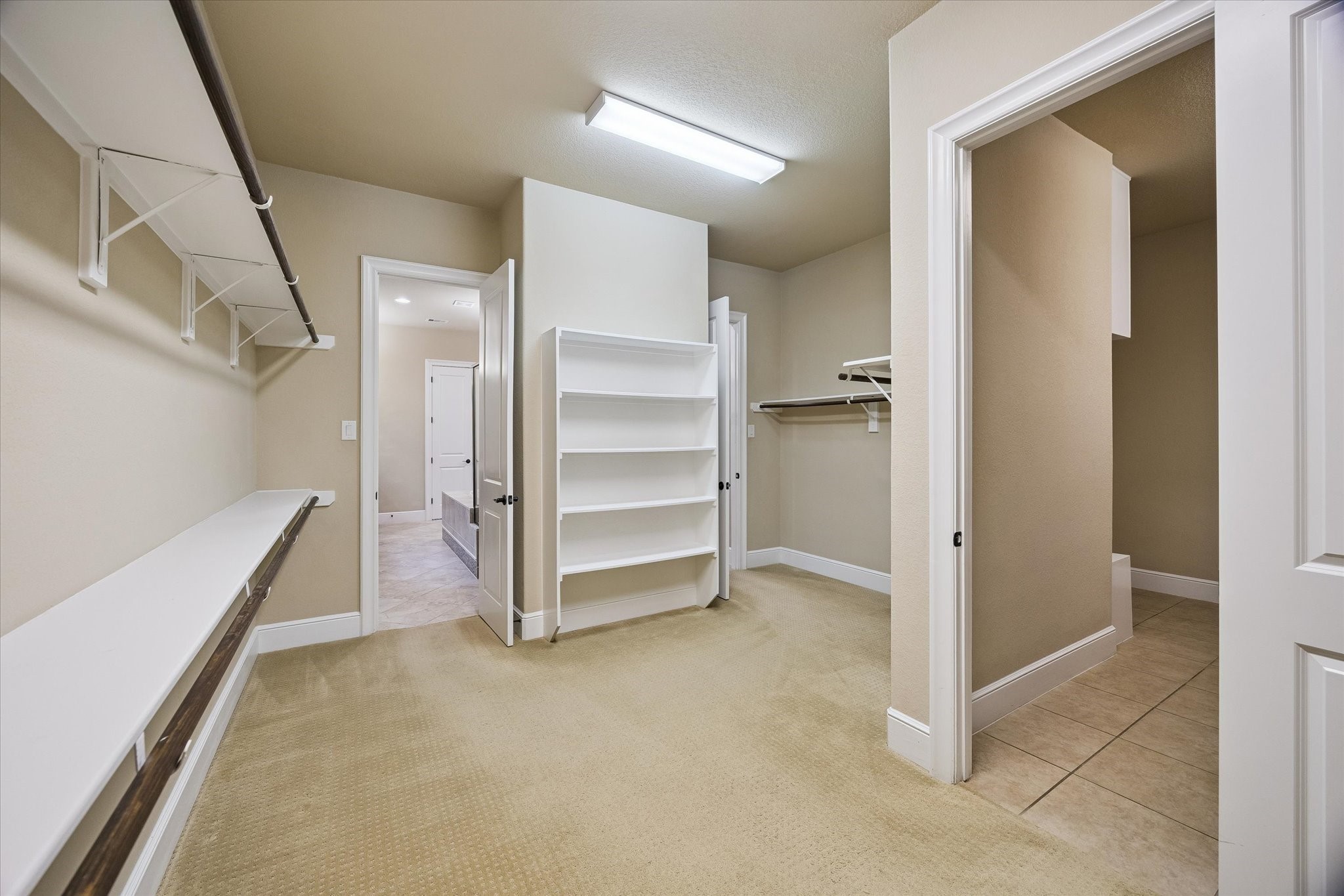 35 North Fremont Ridge Loop Spring, TX 77389 - Photo 18 of 37 The impressive primary walk-in closet provides exceptional storage with generous hanging space, built-in shelving, and a thoughtfully designed layout. Conveniently positioned between the primary bath and laundry room, it offers both luxury and everyday practicality.