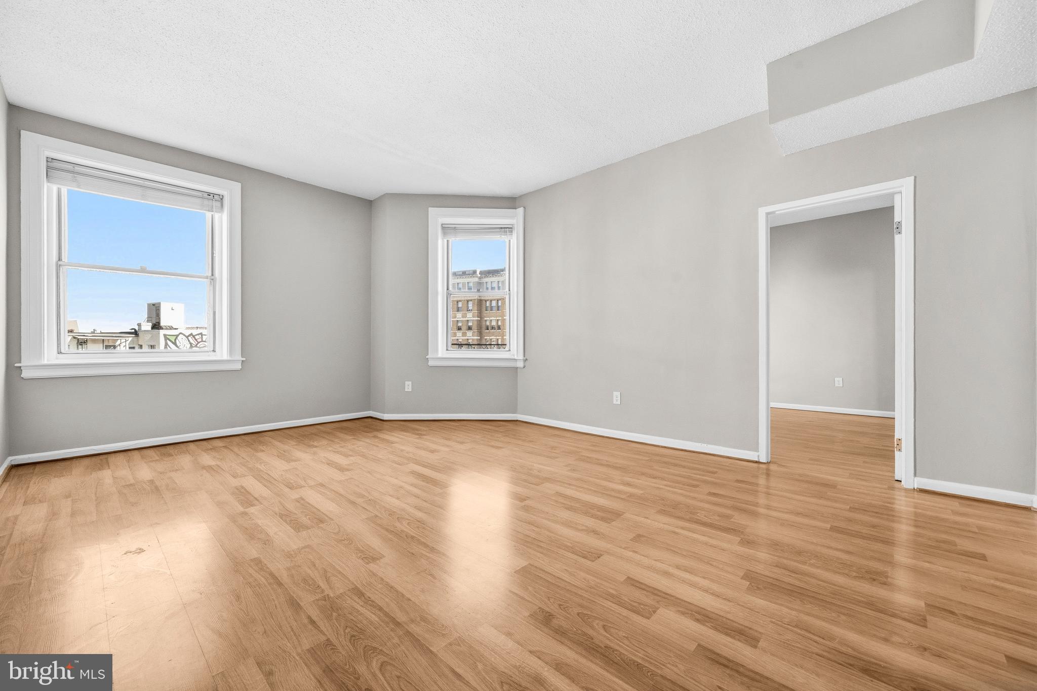 1851 Columbia Road Northwest, Unit 401 Washington, DC 20009 - Photo 7 of 27 a view of an empty room with a window and wooden floor