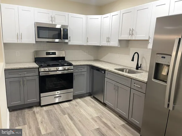 a kitchen with stainless steel appliances granite countertop a stove a sink dishwasher a refrigerator and a microwave