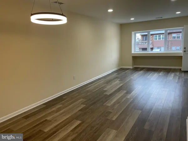 a view of room with window and wooden floor