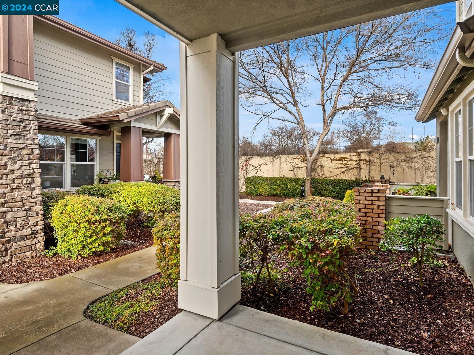 a view of a house with a small yard and potted plants