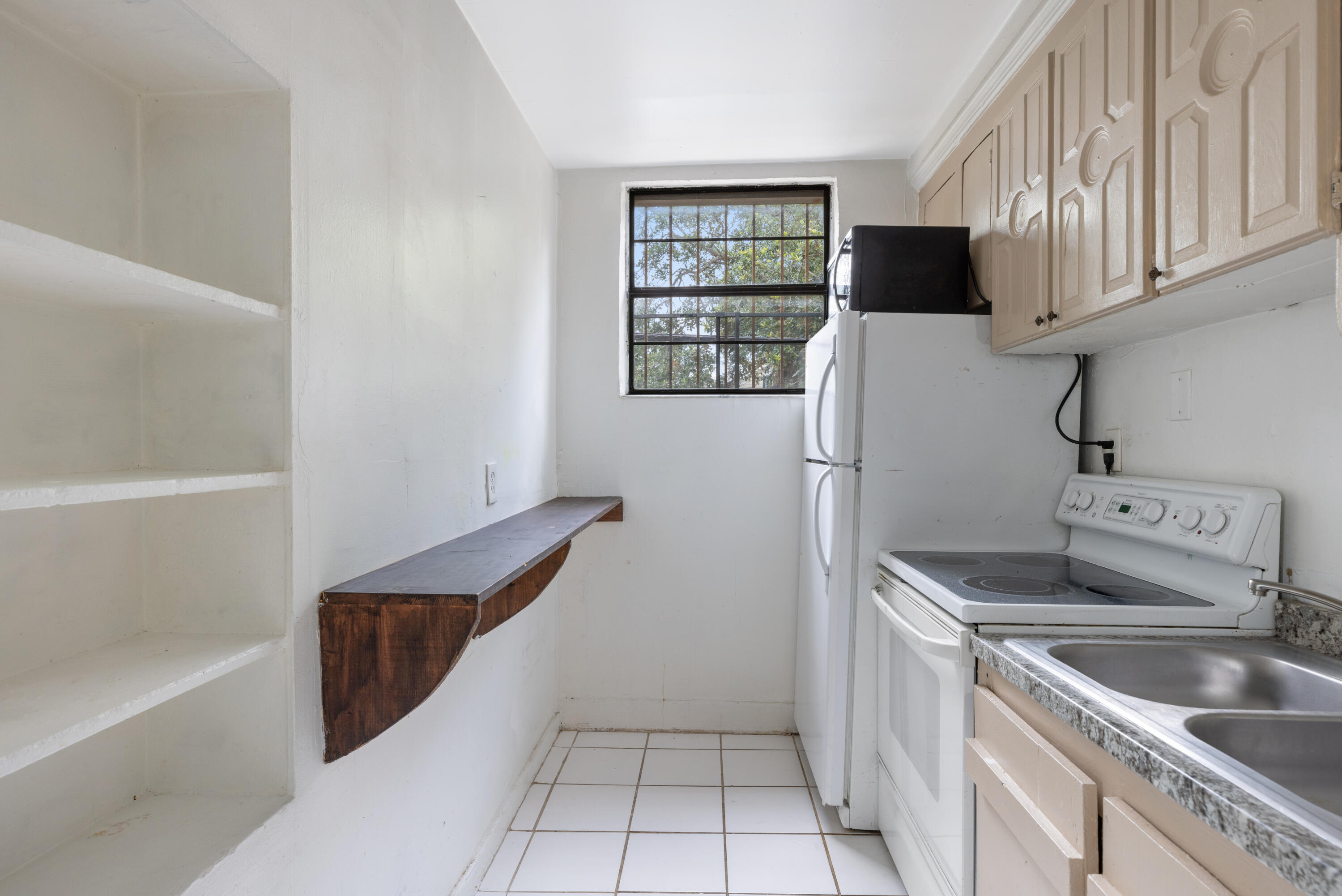 902 Boston Avenue Fort Pierce, FL 34950 - Photo 12 of 34 a kitchen with a refrigerator sink and cabinets