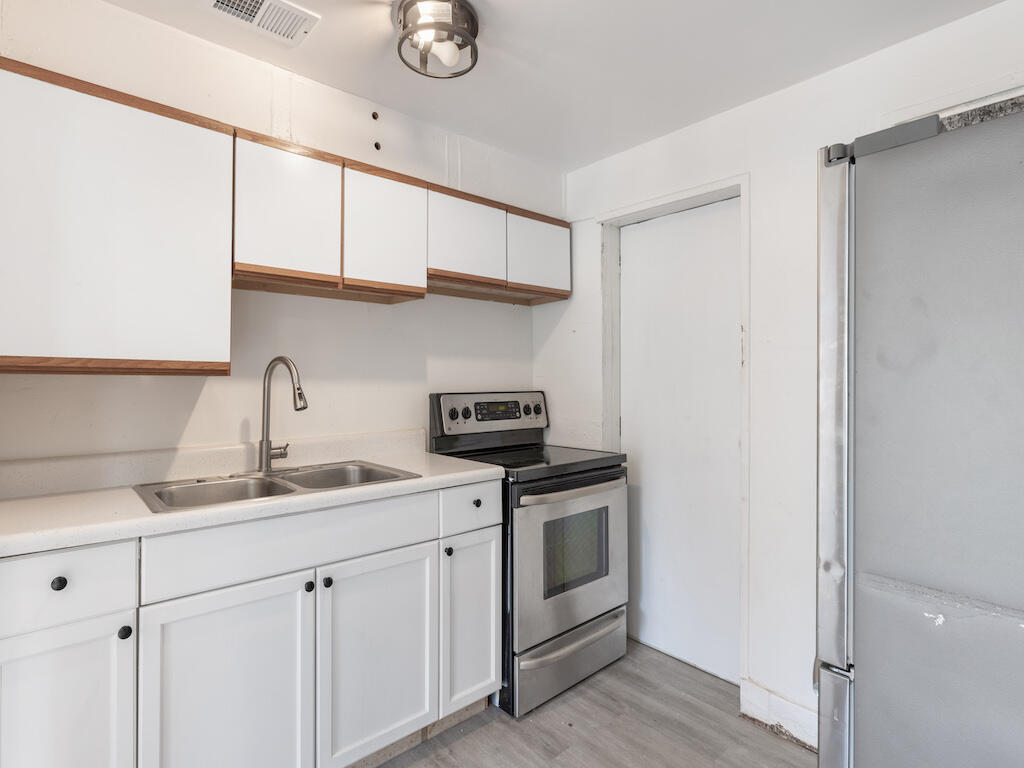 902 Boston Avenue Fort Pierce, FL 34950 - Photo 22 of 34 a kitchen with stainless steel appliances granite countertop white cabinets and a sink