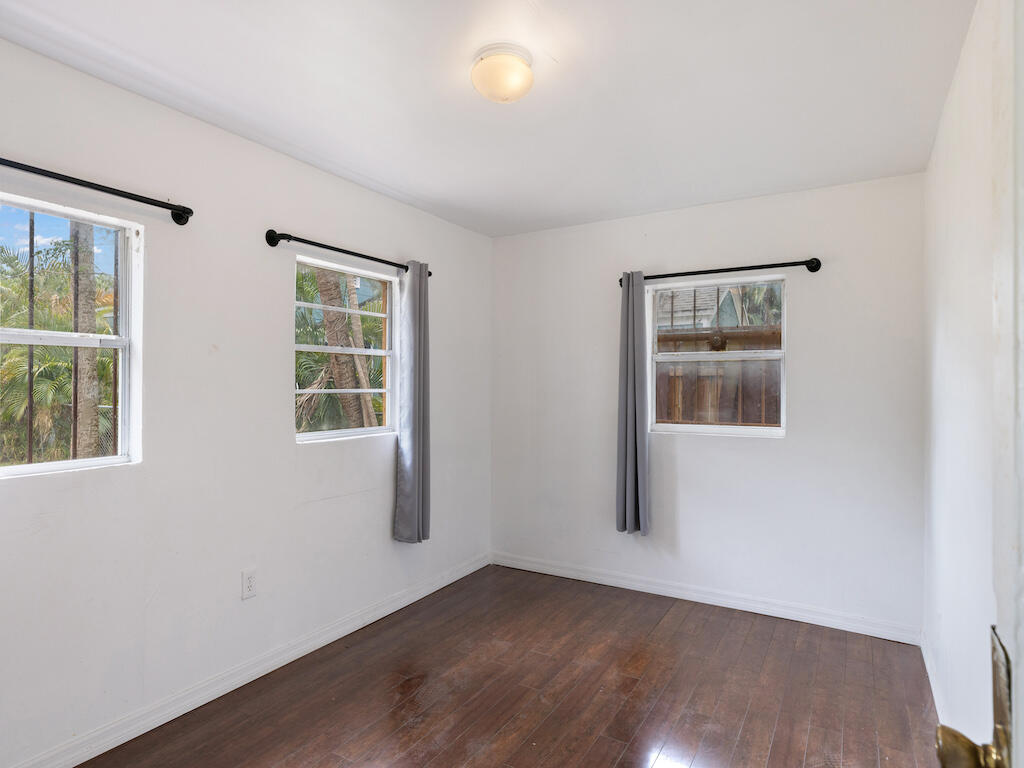 902 Boston Avenue Fort Pierce, FL 34950 - Photo 26 of 34 an empty room with wooden floor and windows