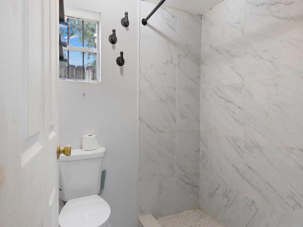 902 Boston Avenue Fort Pierce, FL 34950 - Photo 28 of 34 a white toilet sitting next to a shower curtain
