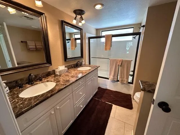 a spacious bathroom with a double vanity sink and a mirror