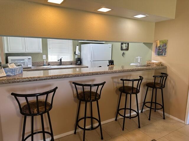 41450 Inverness Way Palm Desert, CA 92211 - Photo 9 of 19 a kitchen with a table chairs sink and cabinets