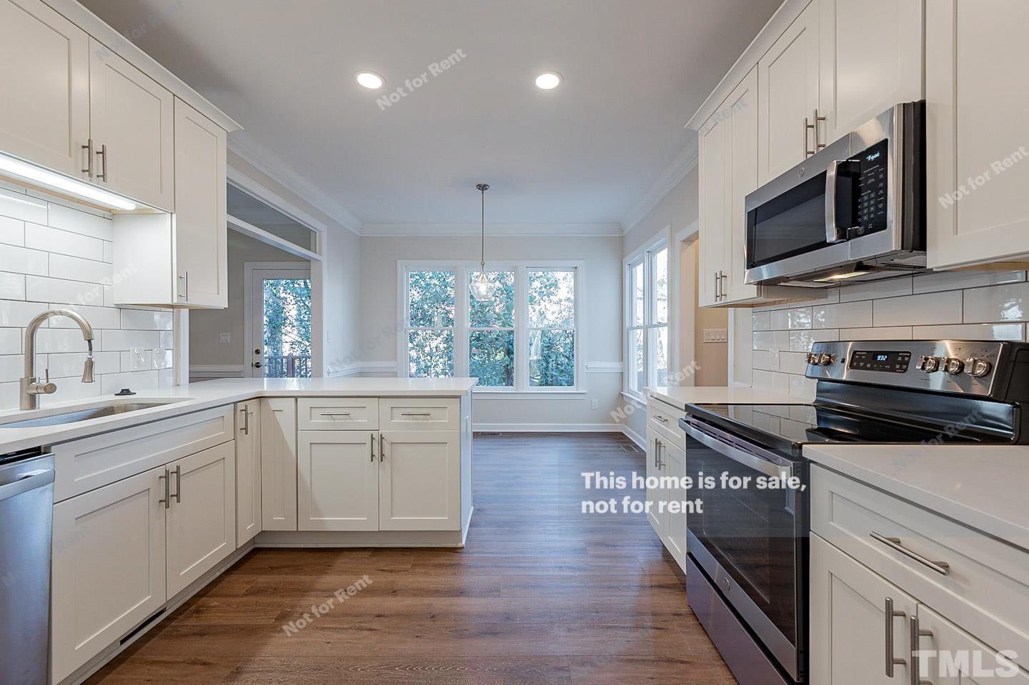 203 Parkgate Drive Cary, NC 27519 - Photo 13 of 31 a kitchen with stainless steel appliances a stove sink microwave and cabinets