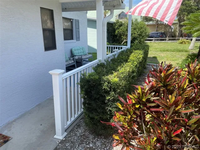 a view of a house with a yard and potted plants