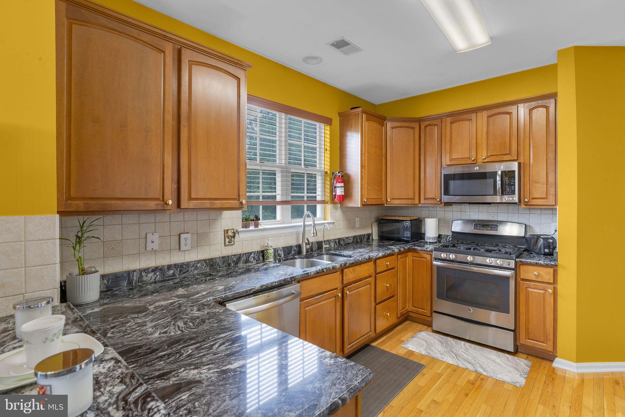 16 Cardiff Court Princeton Junction, NJ 08550 - Photo 16 of 60 a kitchen with stainless steel appliances granite countertop a stove a sink and a microwave
