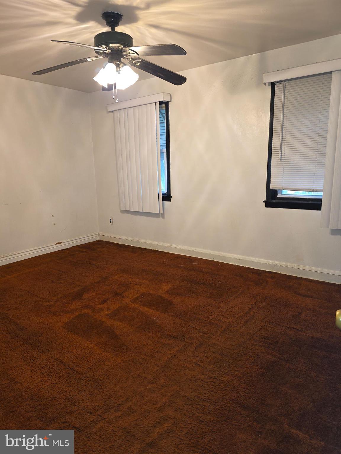 1212 Kevin Road Baltimore, MD 21229 - Photo 7 of 9 an empty room with wooden floor fan and windows