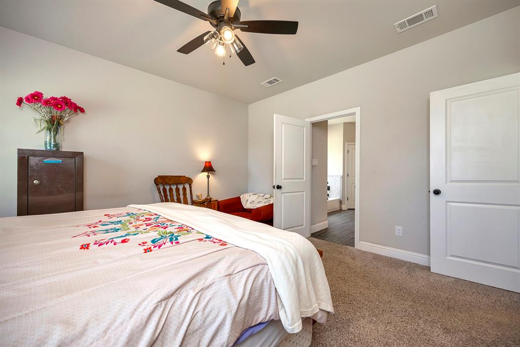 917 East 3rd Street Springtown, TX 76082 - Photo 17 of 32 Primary bedroom with view into en-suite bath.