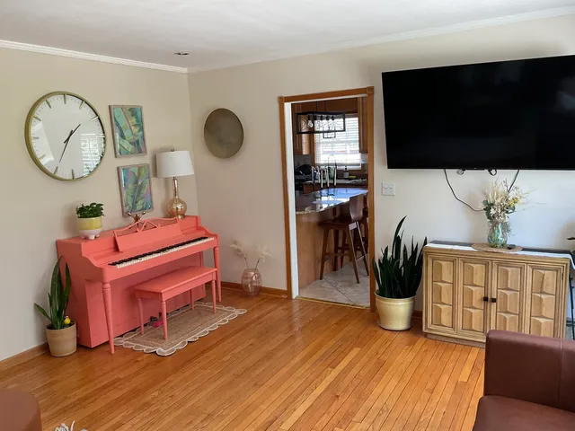 a living room with furniture a flat screen tv and a wooden floor
