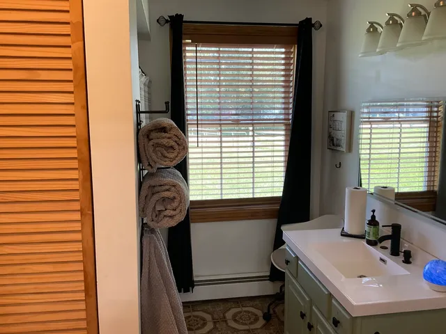 a bathroom with a sink a toilet and a window