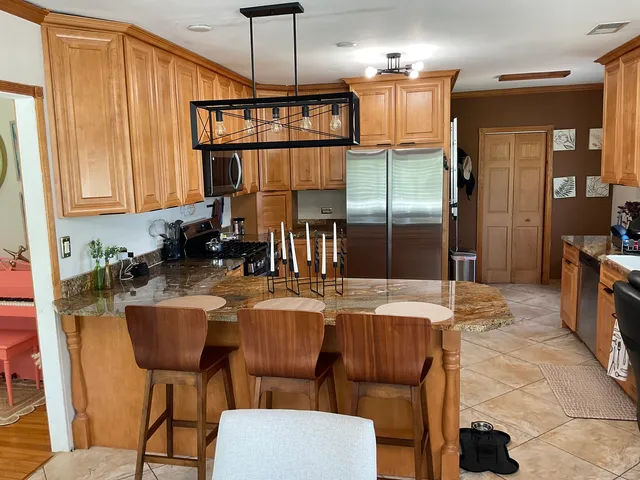 a kitchen with a dining table chairs and refrigerator