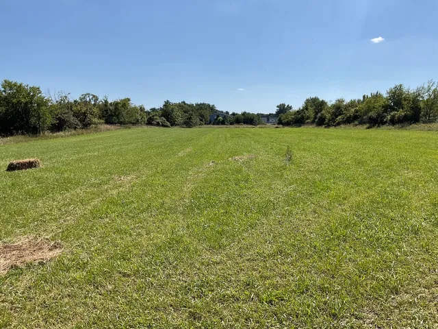 a view of a green field with wooden fence