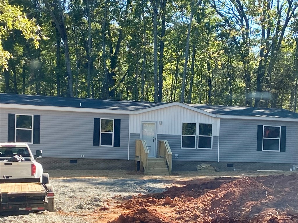 712 Carl Baker Road Starr, SC 29684 - Photo 2 of 10 Mature trees provide a serene natural backdrop for this newly constructed exterior.