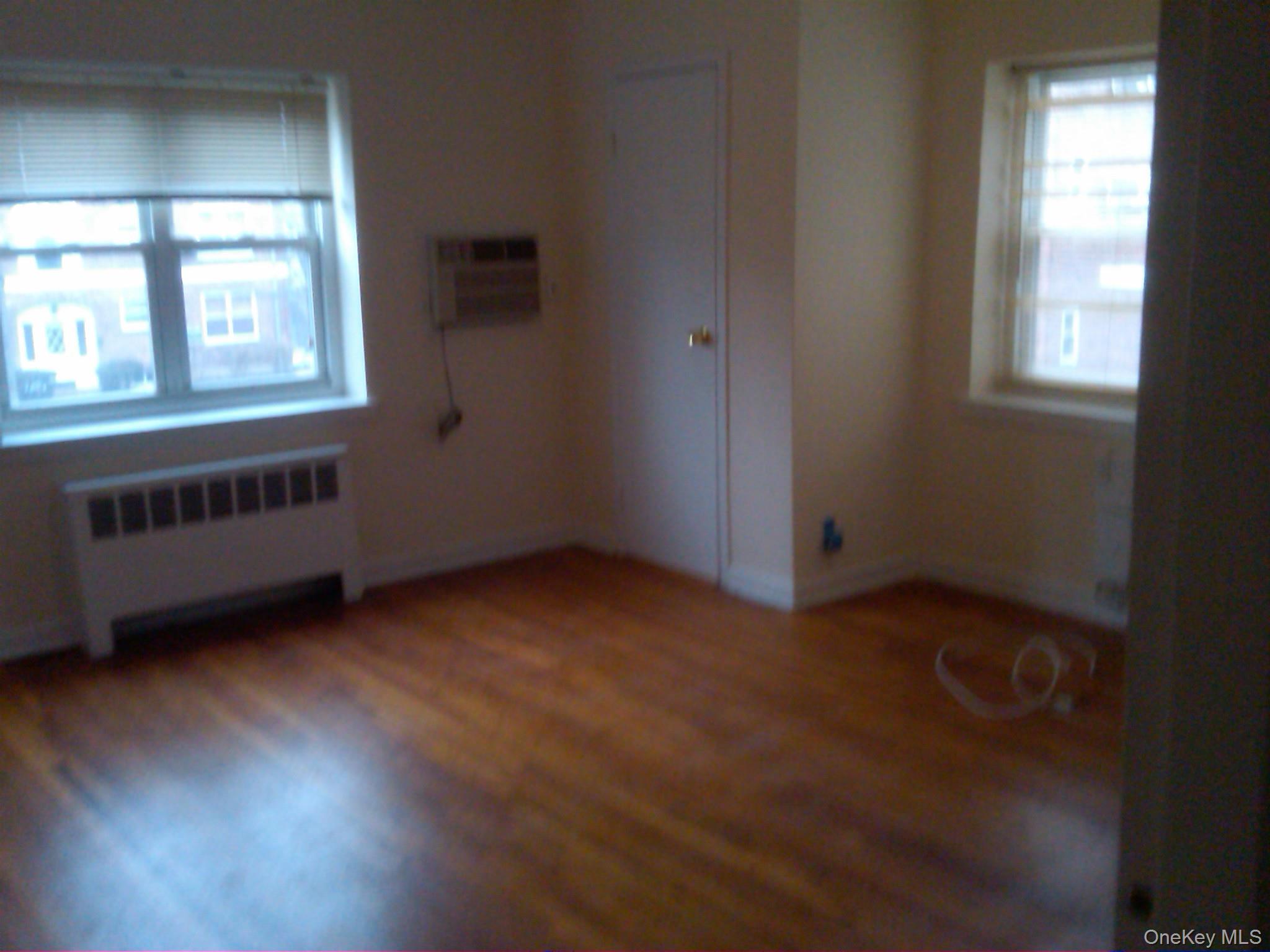 221 Middle Neck Road, Unit H3 Great Neck, NY 11021 - Photo 5 of 9 an empty room with wooden floor and windows