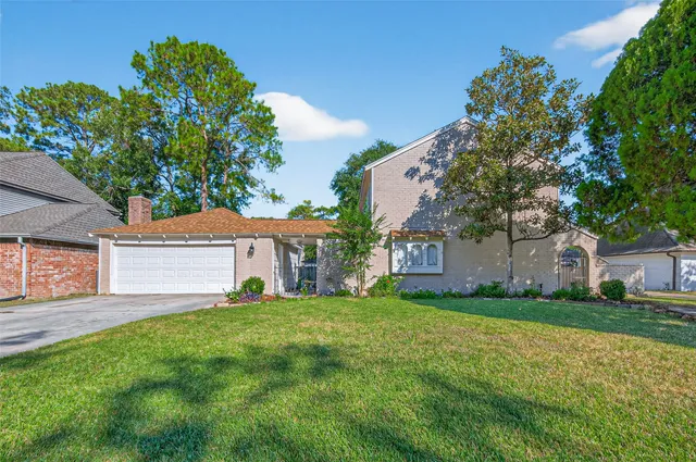 a front view of house with yard and trees in the background