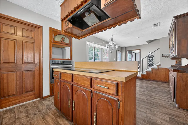a utility room with stainless steel appliances kitchen island wooden floors and large cabinets
