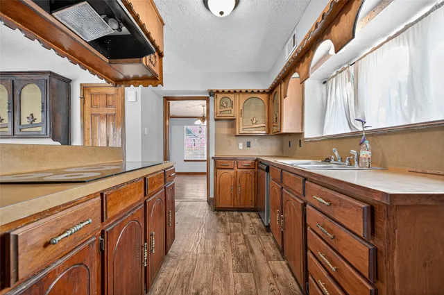 a kitchen with stainless steel appliances granite countertop a sink a stove cabinets counter space and a large window